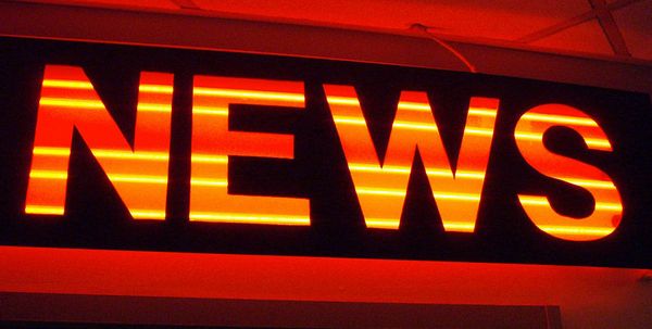 A red and orange neon sign with the word "news"